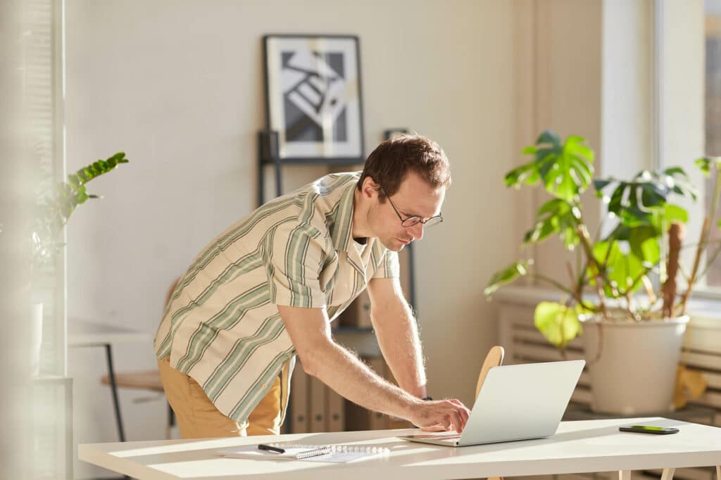 SEO for blog: man standing at desk with his laptop